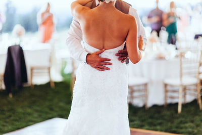 Midsection of newlywed couple dancing during ceremony