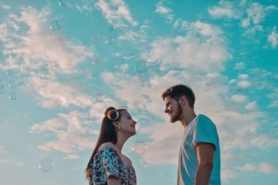 Young couple standing against sky