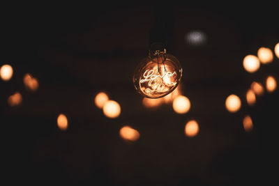 Close-up of illuminated light bulb at night