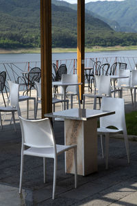 Empty chairs and table in restaurant by buildings