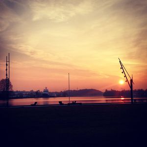 Silhouette bridge over city against sky during sunset