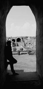 Side view of man in old building against sky