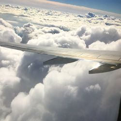 Aerial view of airplane flying over clouds