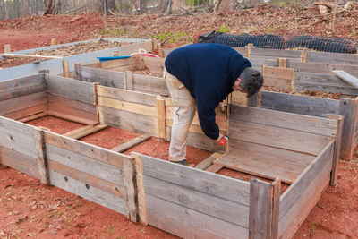 Rear view of man standing on wood