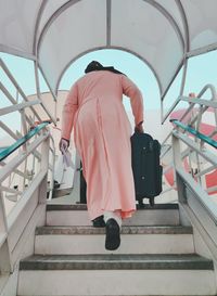 Rear view of woman walking on staircase