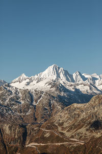 Scenic view of snowcapped mountains against clear blue sky