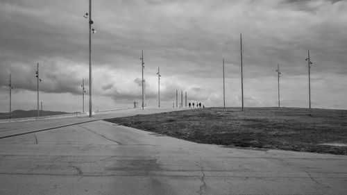 A group of four teenage boys walking along a path in the esplanade of barcelona's forum park, spain. 