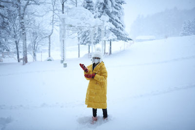 Full length of woman standing on snow