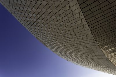 Low angle view of modern building against blue sky