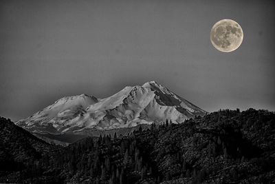 Scenic view of snowcapped mountains against sky at night