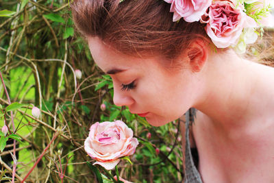 Close-up of beautiful woman smelling rose