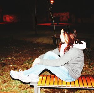 Full length of woman sitting on bench