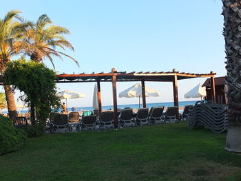 Chairs on beach against clear sky