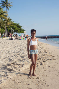 Portrait of smiling young woman standing on beach