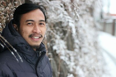 Portrait of smiling man wearing warm clothing during winter