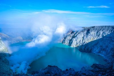 Smoke emitting from volcanic mountain against sky