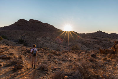 Rear view of woman walking on sand at namib-naukluft national park