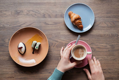 Overhead view of morning breakfast with coffee, croissant and delicious desserts