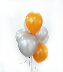 Close-up of orange balloons against white background