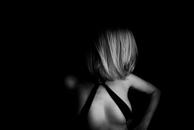 Close-up of sensuous woman against black background