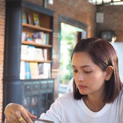 Close-up of woman looking down while holding serving tongs