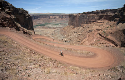 High angle view of man riding bicycle on mountain road at canyonlands national park