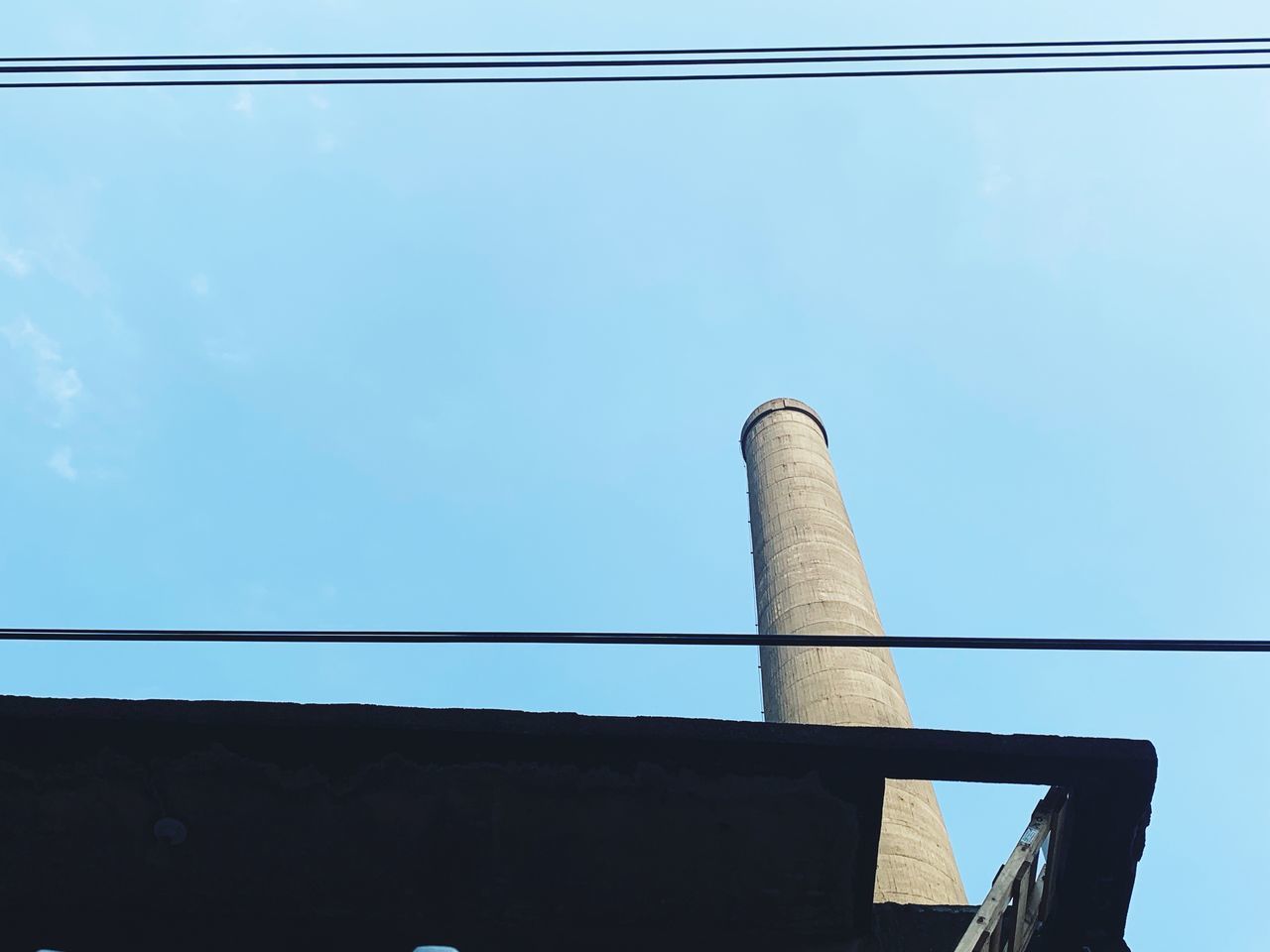 LOW ANGLE VIEW OF SMOKE STACK AGAINST BLUE SKY