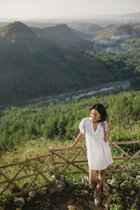 Full length of woman standing on landscape