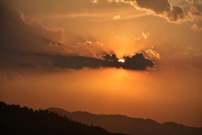 Scenic view of silhouette mountains against romantic sky at sunset