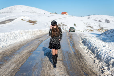 Full length of man walking on snowcapped mountain