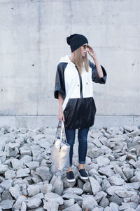 Full length of young woman standing against wall