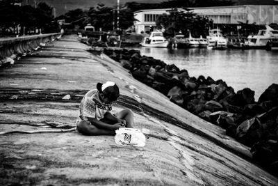 Man sitting on riverbank by river