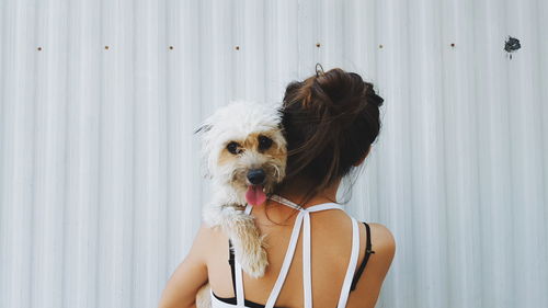 Rear view of woman carrying dog