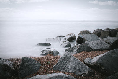 Rocks in sea against sky