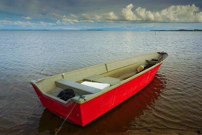 Boat moored on sea against sky