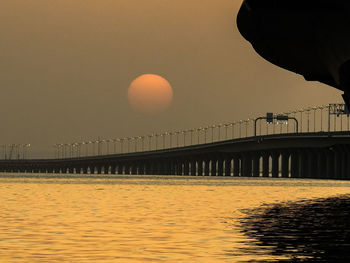 Bridge over river against sky during sunset