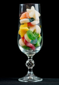 Close-up of fruits served in glass against black background