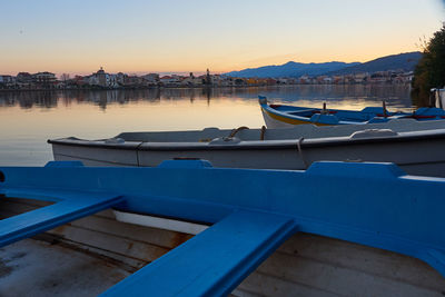 Boats moored at dock during sunset
