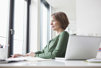 Businesswoman at office desk thinking