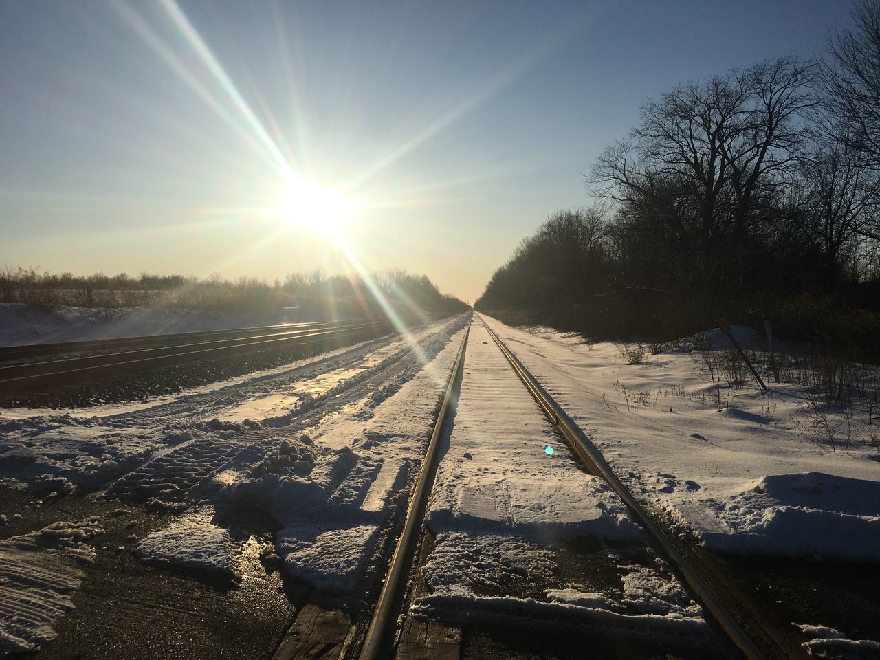 VIEW OF SNOW COVERED RAILROAD TRACKS AGAINST SKY