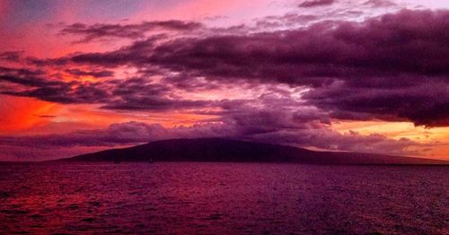 Scenic view of sea against dramatic sky during sunset