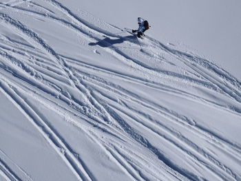 High angle view of person skiing downhill on snow