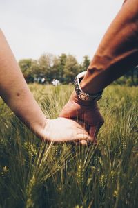 Close-up of friends holding hands