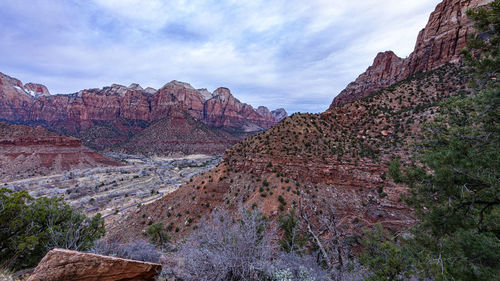 Rock formations on mountain against cloudy sky