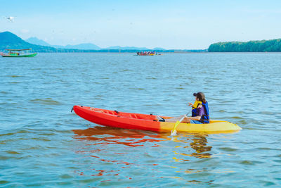 Rear view of person in sea against sky