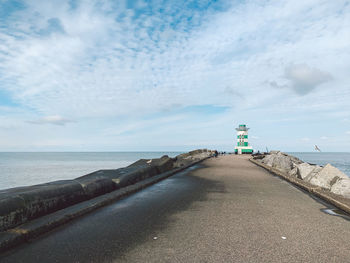 Lighthouse by sea against sky