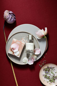 Still life of skin care product, flower pedals, plates