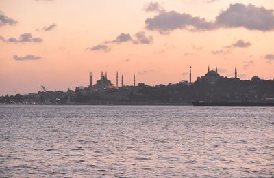 View of mosque and buildings against sky during sunset