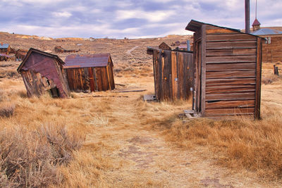 Old barn on field against sky