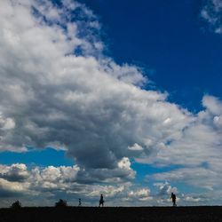 People on landscape against blue sky